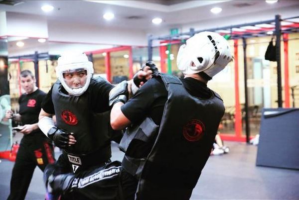 Krav Maga students doing sparring under the supervision of a Krav Maga instructor